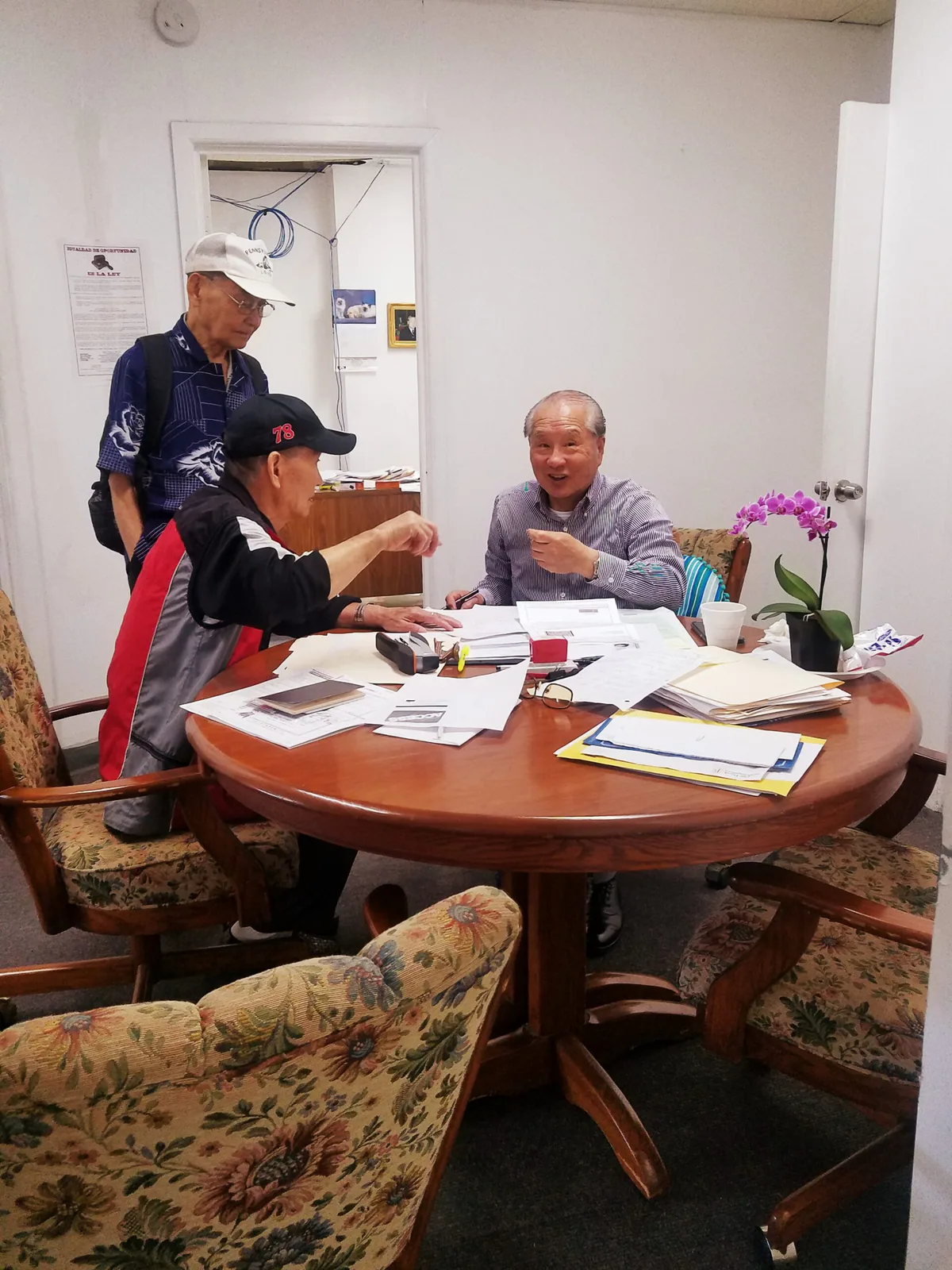 Two people reviewing documents in a small office.