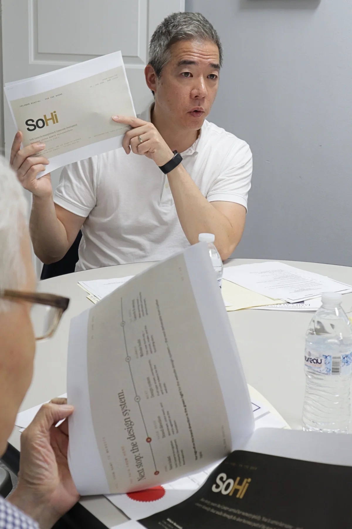 Don Yu presenting the SoHi identity and story materials during a board meeting.
