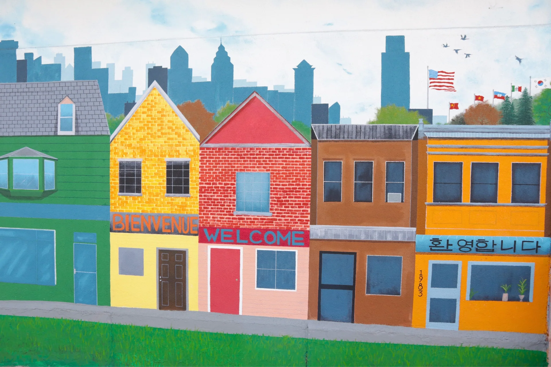 A neighborhood mural outside SoHi Center says welcome in Spanish, English, and Korean.